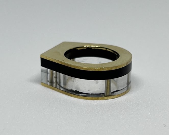 image of brass rivet ring, with layers of black and clear acrylic in between